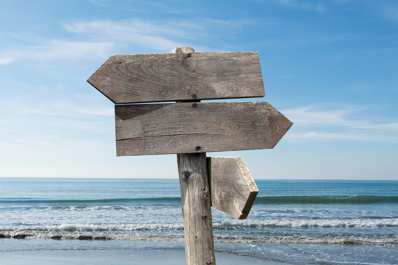summer travel destinations options direction road sign with wooden arrows beach sea min